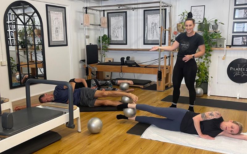 Mat work being peformed, during a pilates session.